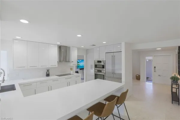 a kitchen with kitchen island a stove a table and chairs in it