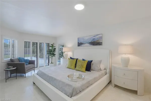 a bedroom with a bed and a potted plant