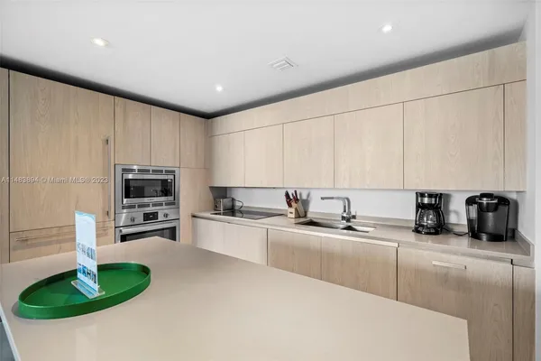 a kitchen with granite countertop a sink stainless steel appliances and cabinets