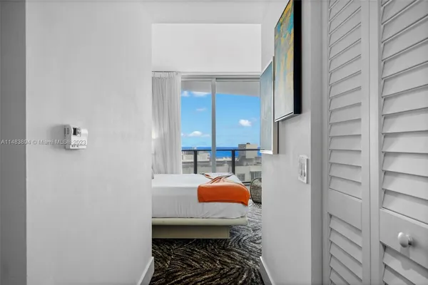 a bedroom with a bed and glass door