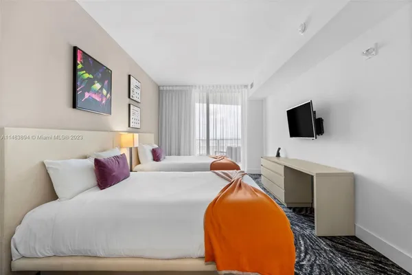a bedroom with a bed and a flat screen tv