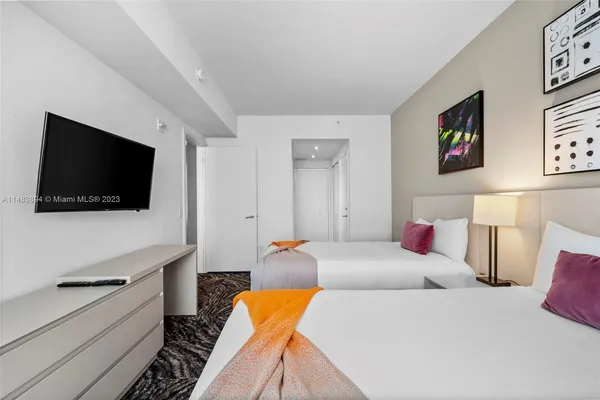 a bedroom with a bed and a flat screen tv