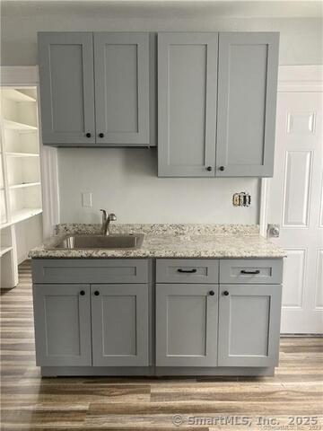 15-17 Ridgewood Street, Unit 2 Waterbury, CT 06710 - Photo 4 of 8 a kitchen with granite countertop white cabinets and sink