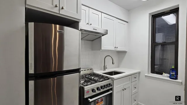 a kitchen with stainless steel appliances a refrigerator a sink and cabinets