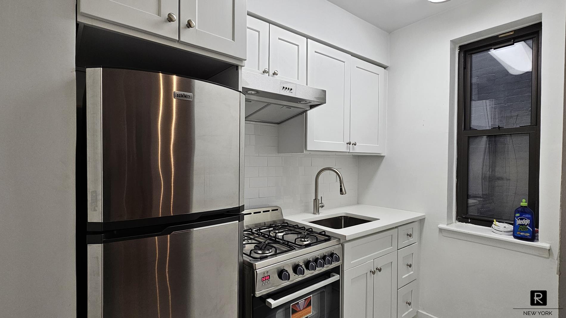 46 West 65th Street, Unit 3D Manhattan, NY 10023 - Photo 3 of 6 a kitchen with stainless steel appliances a refrigerator a sink and cabinets