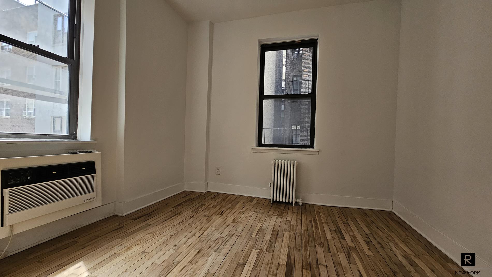 46 West 65th Street, Unit 3D Manhattan, NY 10023 - Photo 5 of 6 a view of empty room with wooden floor and fan