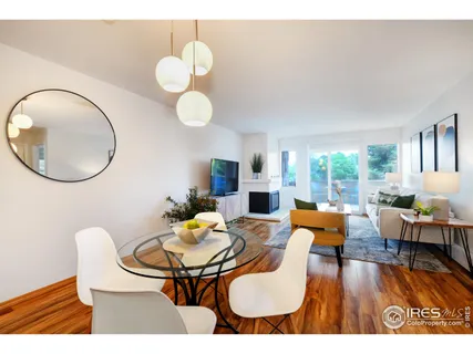 a dining room with wooden floor a chandelier a glass table and chairs