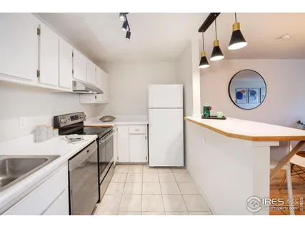 a kitchen with a sink a stove top oven and clock on the wall