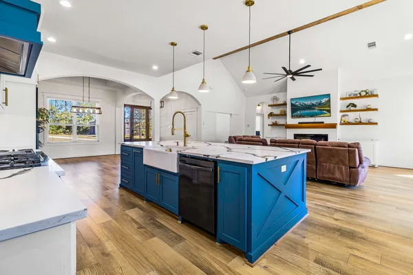 a kitchen with granite countertop a sink a counter space appliances and cabinets