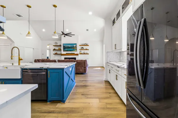 a large kitchen with stainless steel appliances granite countertop a stove a sink and a refrigerator