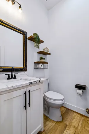 a bathroom with a granite countertop sink and a toilet