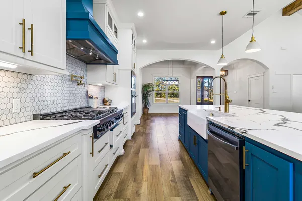 a large kitchen with granite countertop a stove and a sink