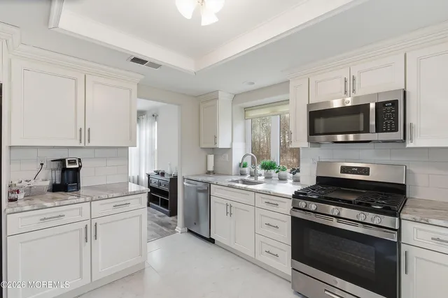 a kitchen with appliances a sink and cabinets
