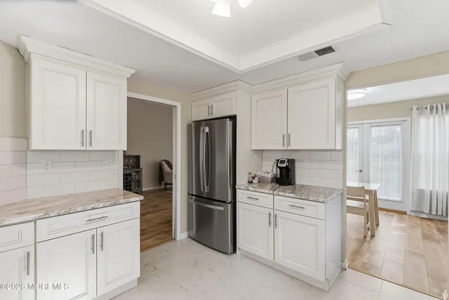 a kitchen with white cabinets and stainless steel appliances