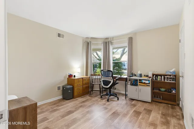 a view of a workspace with furniture and a window
