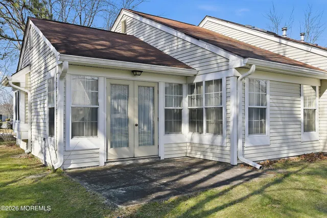 a view of a house with a small yard and wooden floor and fence