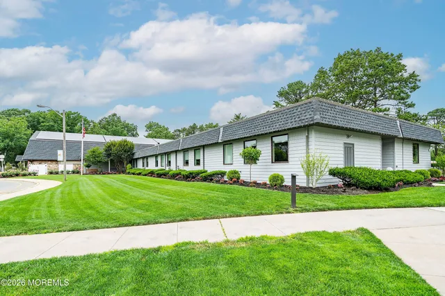 a view of house with a big yard and potted plants