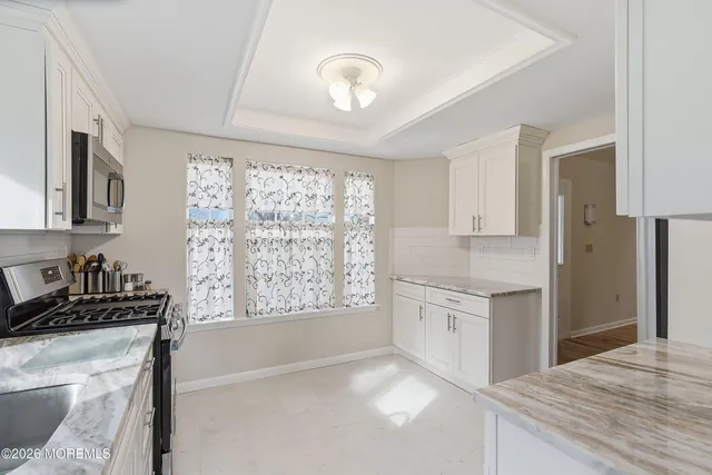 a kitchen with granite countertop a stove a sink and a refrigerator