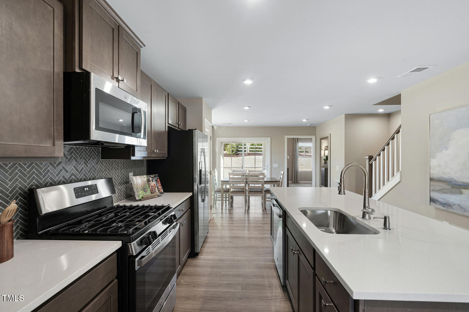 1328 Rollman Farm Road Raleigh, NC 27603 - Photo 6 of 26 a kitchen with stainless steel appliances granite countertop a sink a stove top oven a counter space and cabinets