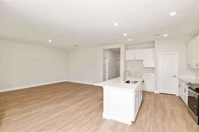 a kitchen with a sink a stove and cabinets