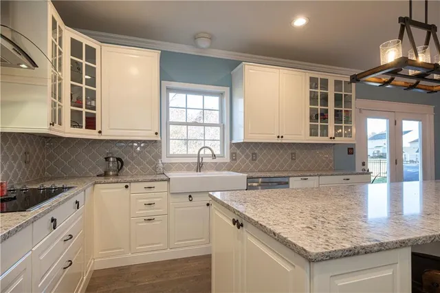 a kitchen with granite countertop a sink stainless steel appliances and cabinets