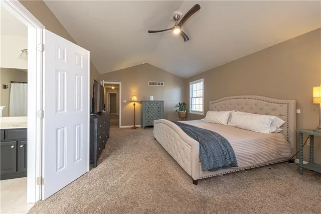 a spacious bedroom with a bed and a chandelier