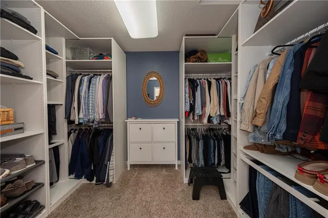 a view of walk in closet with clothes and shoes