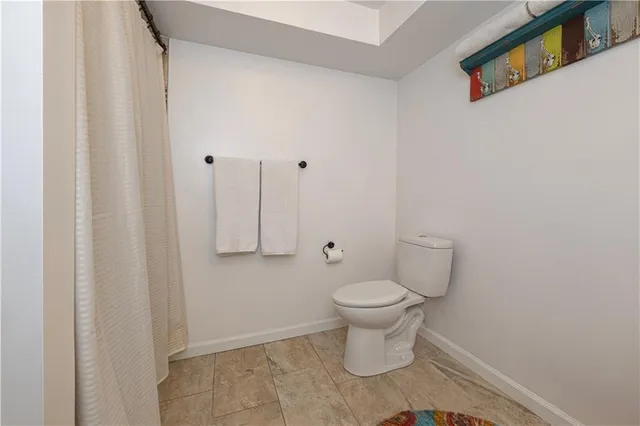 a white toilet sitting next to a shower curtain