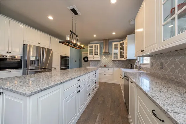 a kitchen with stainless steel appliances granite countertop a sink stove and refrigerator