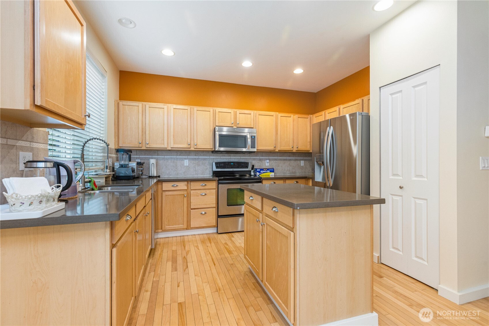 28104 Maple Ridge Way Southeast Maple Valley, WA 98038 - Photo 6 of 26 a kitchen with stainless steel appliances granite countertop a refrigerator a sink dishwasher a stove with wooden cabinets and floor