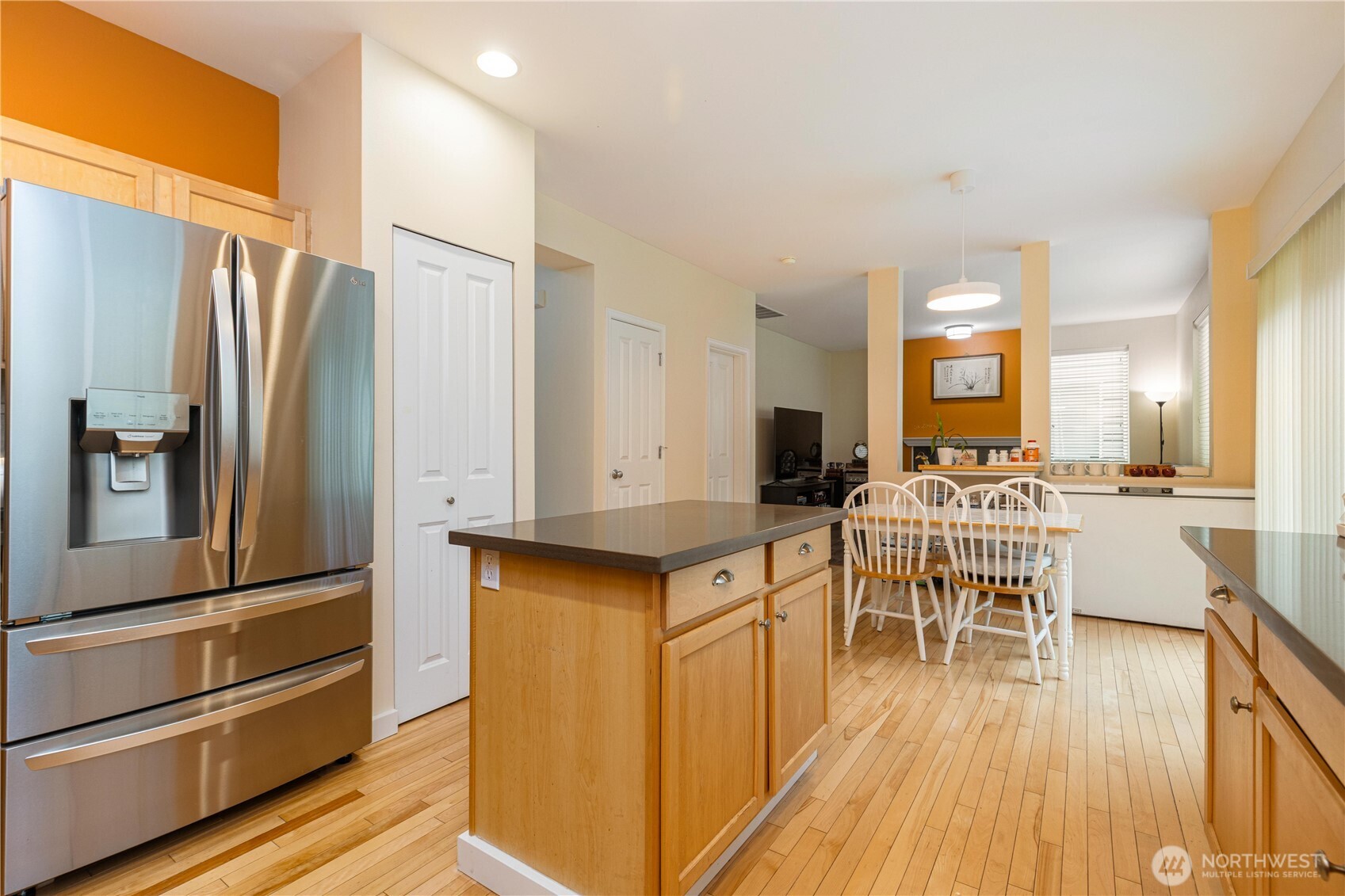 28104 Maple Ridge Way Southeast Maple Valley, WA 98038 - Photo 8 of 26 a kitchen with stainless steel appliances granite countertop a stove top oven a refrigerator a dining table and chairs with wooden floor