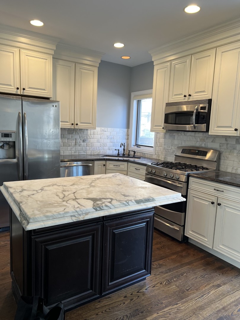 Undisclosed Address Chicago, IL 60614 - Photo 7 of 22 a kitchen with kitchen island granite countertop a sink cabinets and stainless steel appliances