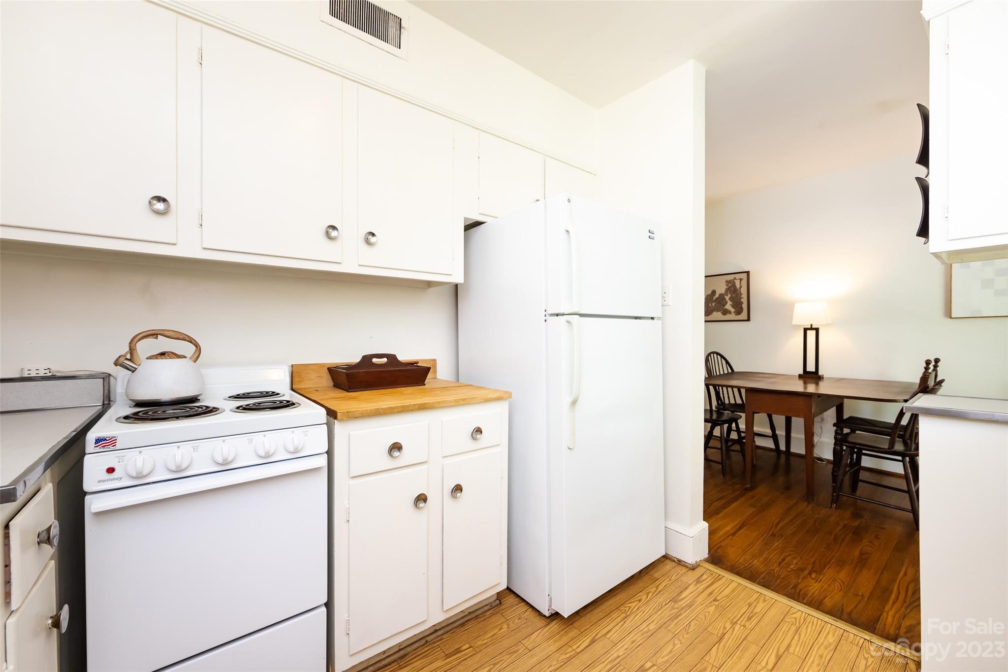 1011 Andover Road Charlotte, NC 28211 - Photo 17 of 29 a kitchen with a stove a refrigerator and a dining table