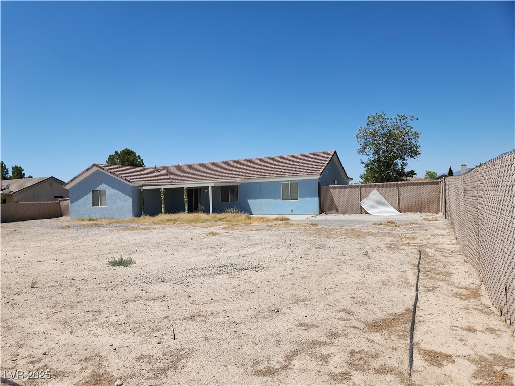 161 Diamond Bar Road Pahrump, NV 89048 - Photo 23 of 29 Rear view of property with a fenced backyard, stucco siding, and a tile roof