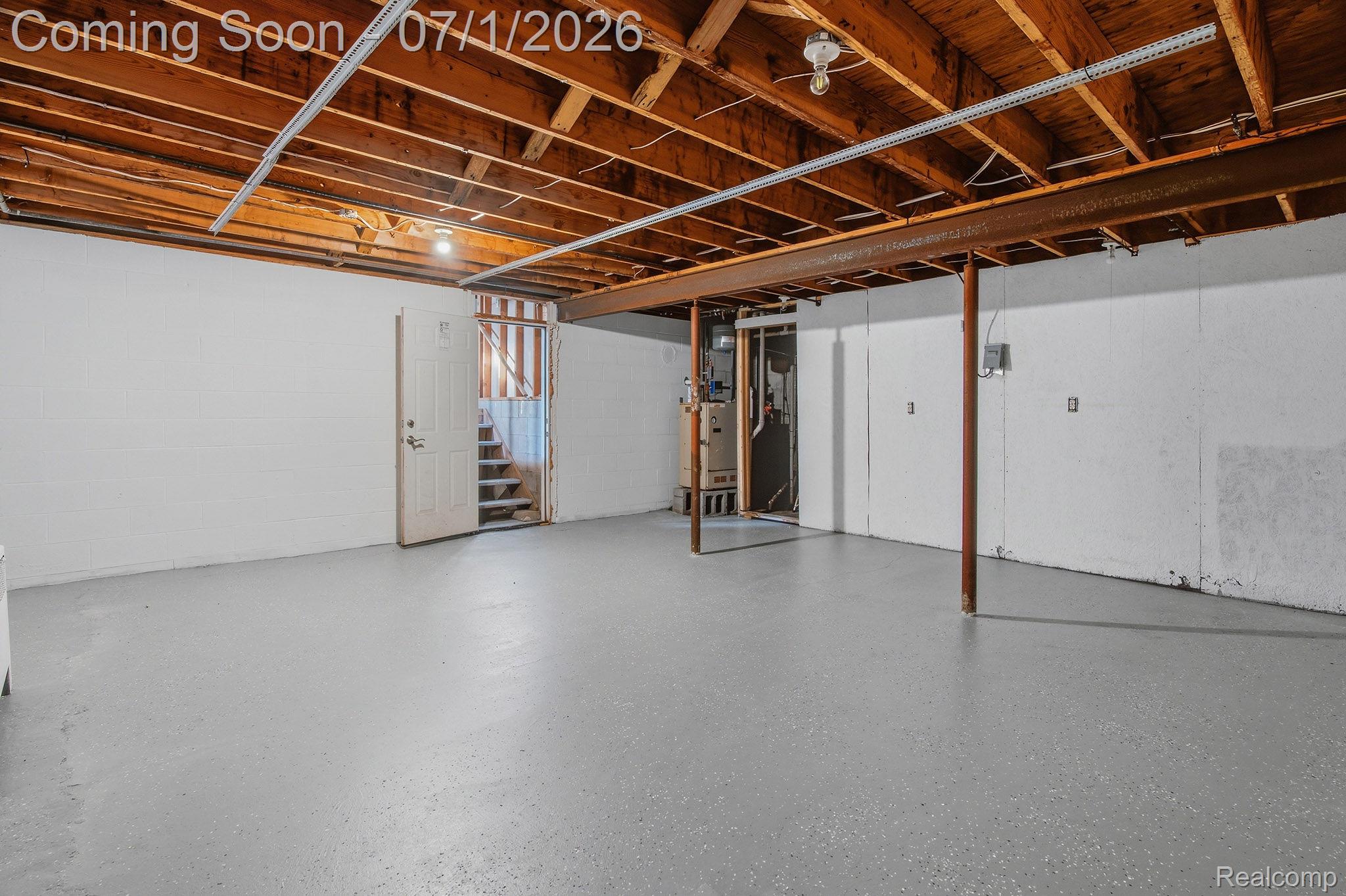 4762 Lonsberry Road Columbiaville, MI 48421 - Photo 28 of 36 Spacious lower level featuring exposed wood beam ceiling, concrete flooring, white painted walls, and a utility area with visible mechanical systems
