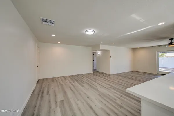 a view of an empty room and window and wooden floor