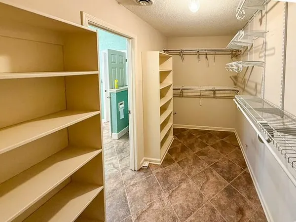 a view of walk in closet with empty racks