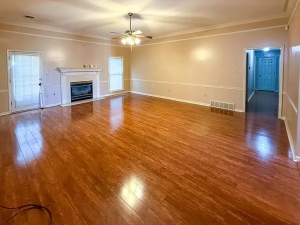 an empty room with wooden floor and fireplace