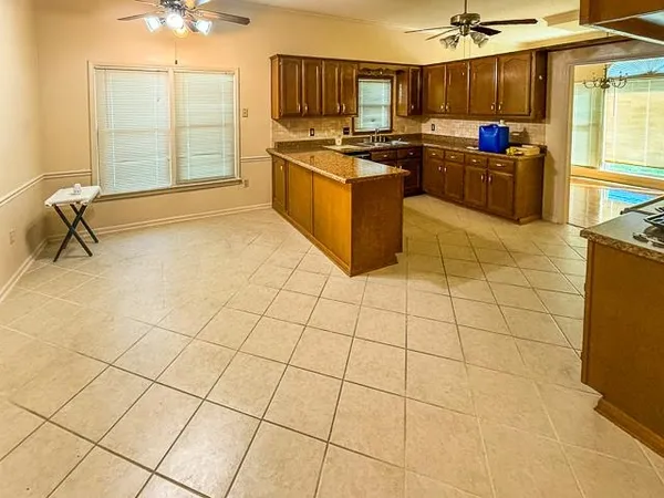 a kitchen with stainless steel appliances kitchen island granite countertop a sink and a counter space