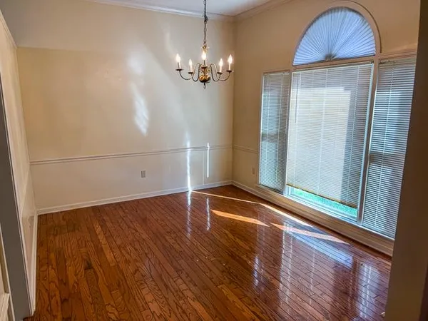 a view of a room with wooden floor and chandelier