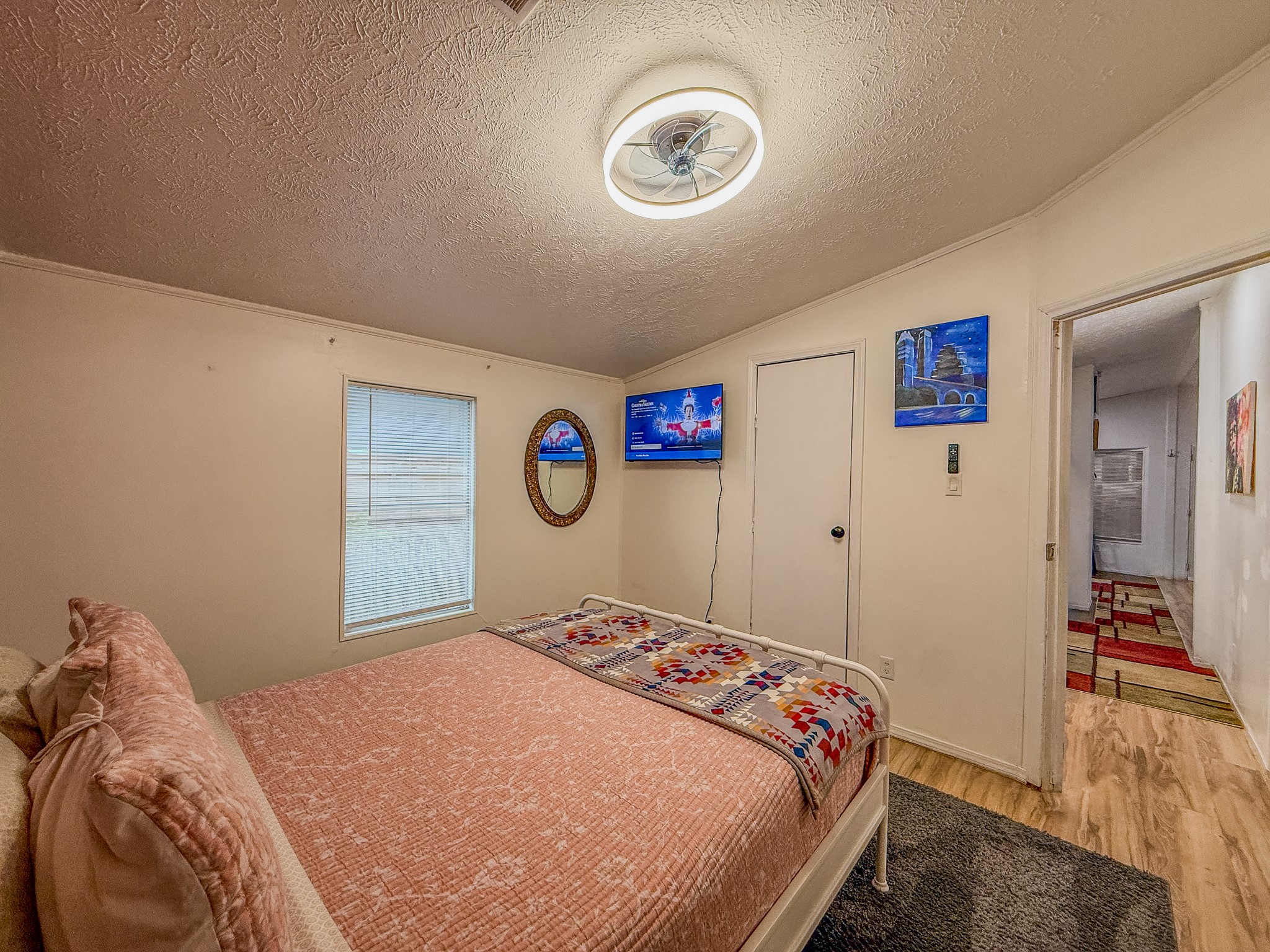 2015 Holly Street Austin, TX 78702 - Photo 12 of 24 Naturally illuminated sleeping quarters featuring durable wood-like flooring and a quiet ceiling fan for comfort.