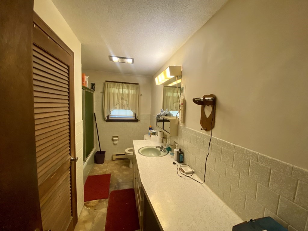 16 Peabody Road Shirley, MA 01464 - Photo 13 of 20 a bathroom with a sink a toilet and mirror