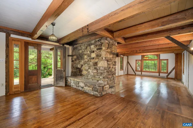 a view of empty room with wooden floor and floor to ceiling window