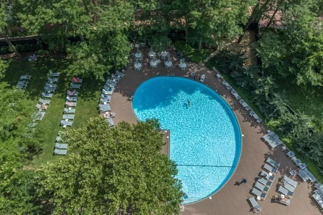 an aerial view of a house with outdoor space and trees all around
