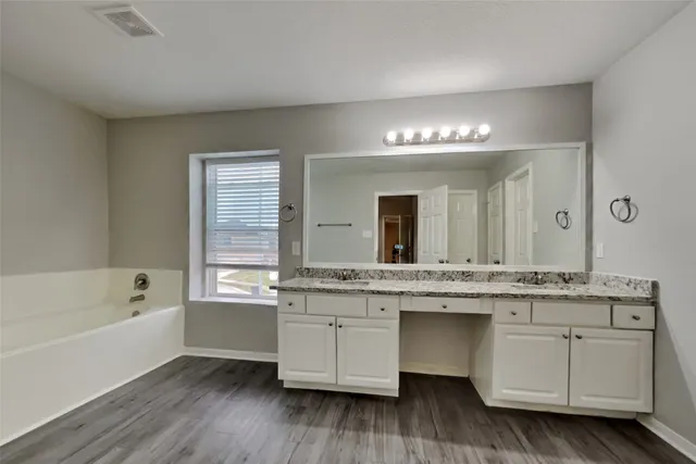 en empty room with windows and ceiling fan