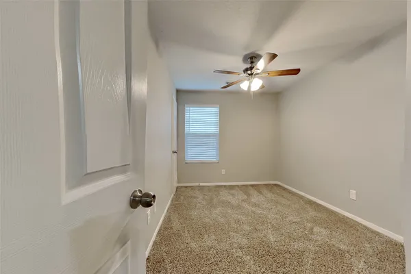 a hall with wooden floor and cabinets