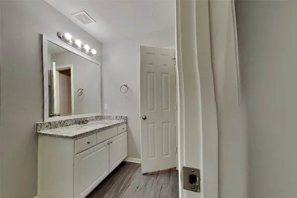 a bathroom with a granite countertop sink and a mirror