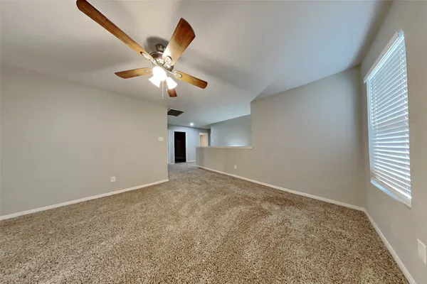 a view of a livingroom with a ceiling fan and window