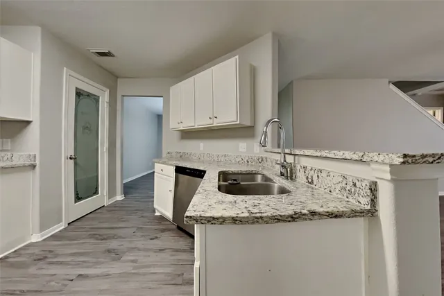 a kitchen with granite countertop a sink stove and cabinets