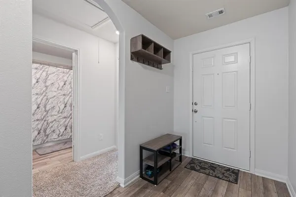 a view of room with hardwood floor and a ceiling fan